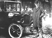 Henry Ford met zijn beroemde, op de lopende band vervaardigde T-Ford in 1908.