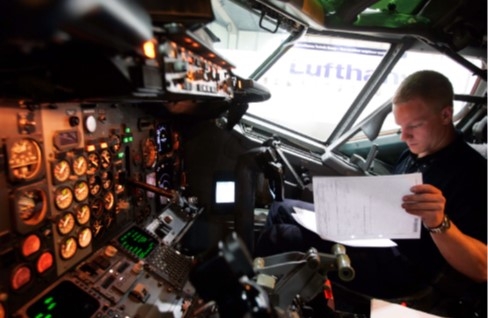 Het raadplegen van een ATL in de cockpit van een vliegtuig.