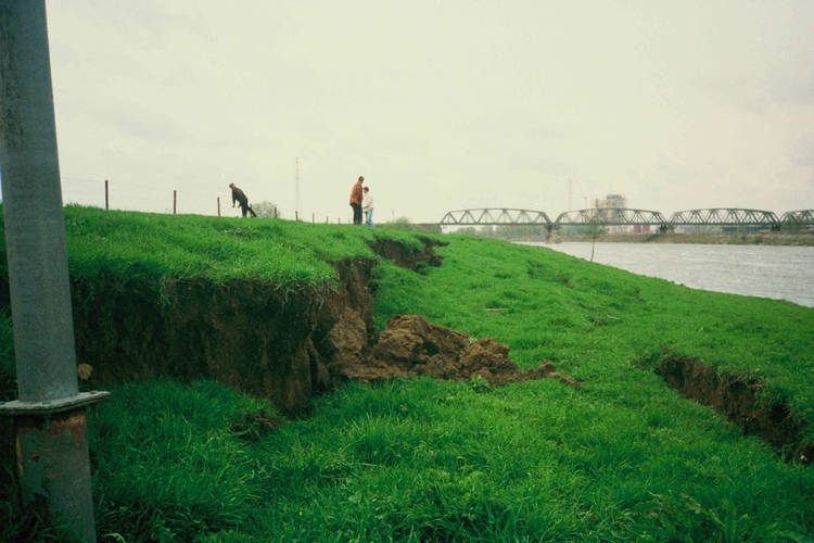 Waterkeringschade door aardbeving bij Roermond in 1992. Je ziet scheuren in de rechteroever van de Maas bij Leeuwen, tegenover Buggenum. (Bron: https://beeldbank.rws.nl, Rijkswaterstaat / Henk Bakker)