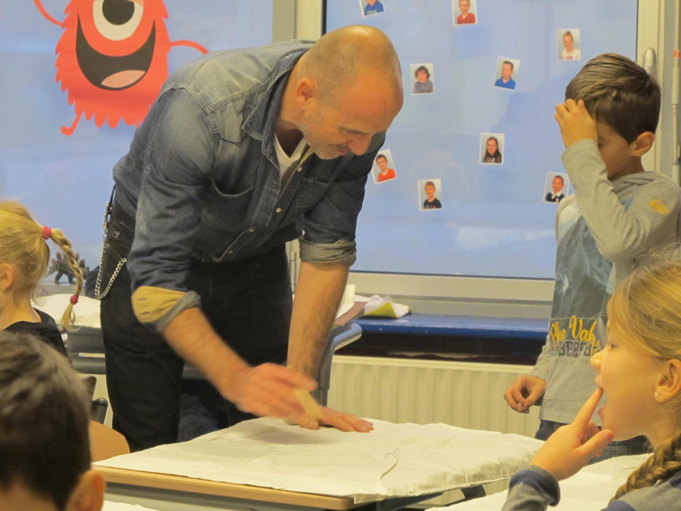 Paul Klemann geeft een workshop dromen op kussenslopen schilderen aan groep 4