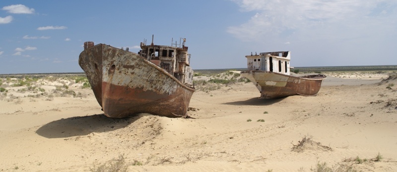 De haven van Monyaq. Het water van het Aralmeer is verdwenen, de vissersboten zijn achtergebleven.