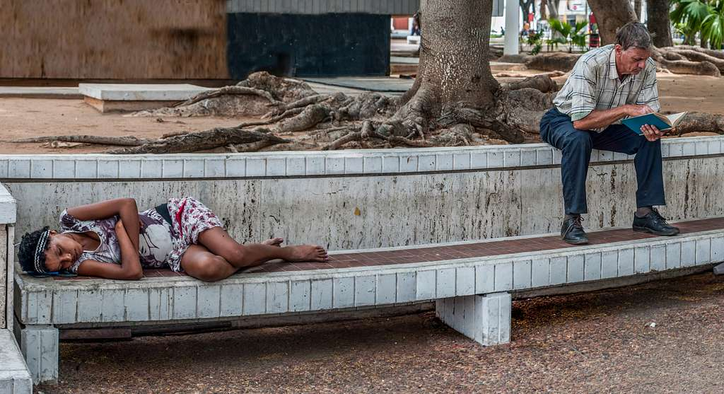 Degene die op het bankje ligt is dakloos, als je dit weet hoe zie je dan sociale ongelijkheid terug op de foto?